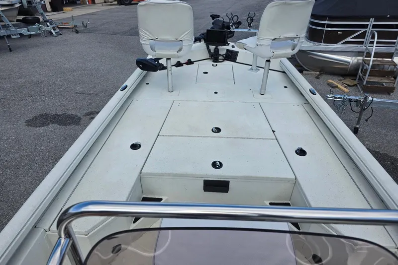 Slide: The Image of 2022 Ranger RB200 boat deck with seating and fishing rod holders, parked on pavement. - 8