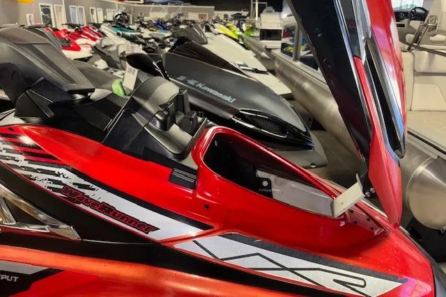 Slide: The Image of 2015 Yamaha WaveRunner VXR in showroom, red and black design, open storage compartment. - 12