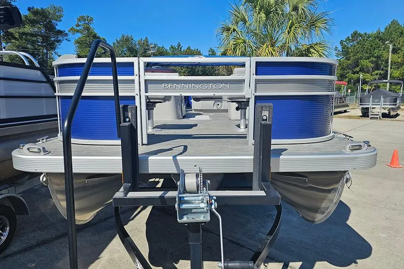 Slide: The Image of 2021 Bennington SX 22 Fishing pontoon boat on trailer, blue and silver design. - 4