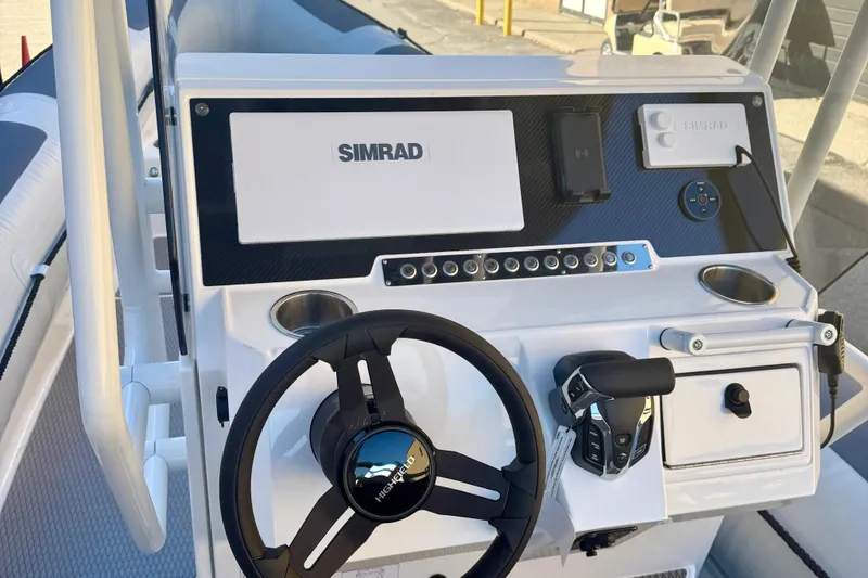 Slide: The Image of Control panel of 2025 Highfield Patrol 760 boat with buttons and cup holders. - 18