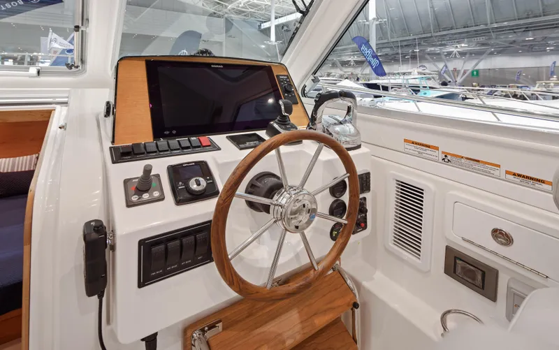 Slide: The Image of Helm of 2026 Back Cove 340 boat with wooden steering wheel and modern controls. - 12