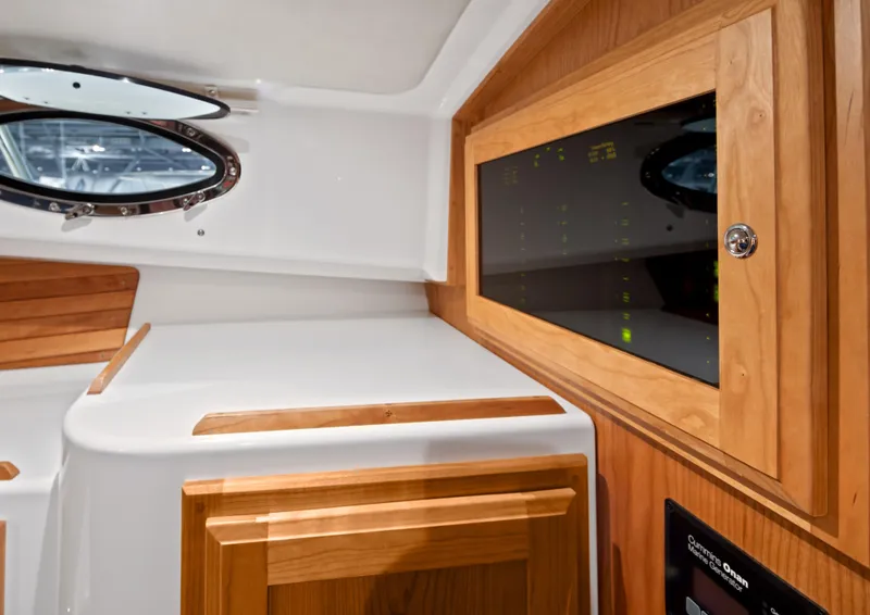 Slide: The Image of Interior of 2026 Back Cove 340 boat with wood paneling and porthole window. - 13