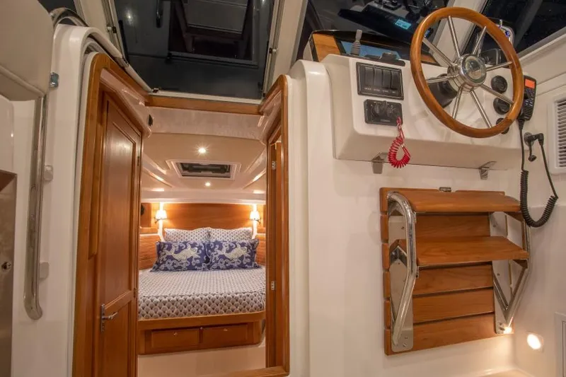 Slide: The Image of 2026 Back Cove 340 interior with cozy cabin, wooden accents, and steering wheel. - 16