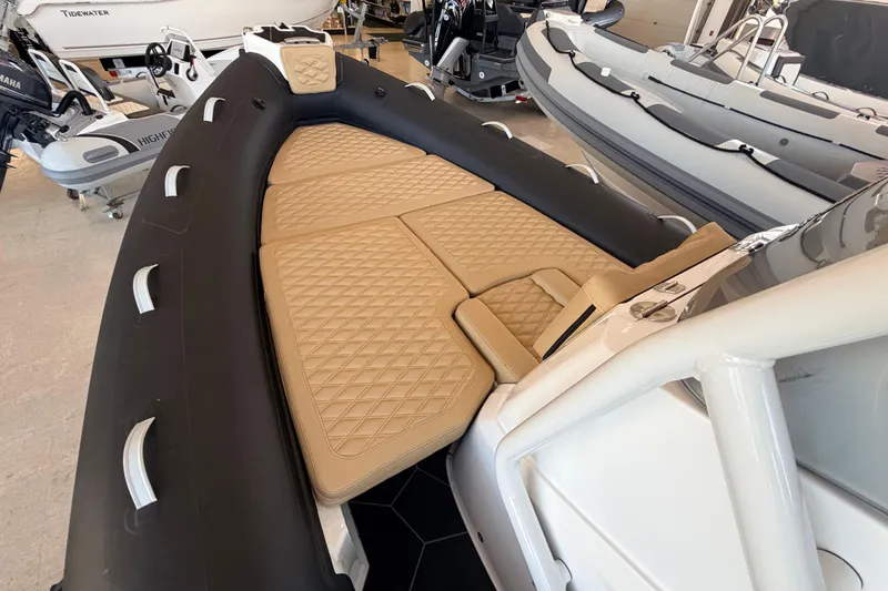 Slide: The Image of 2026 Highfield Sport 660 boat with tan quilted seating and sleek black exterior. - 17