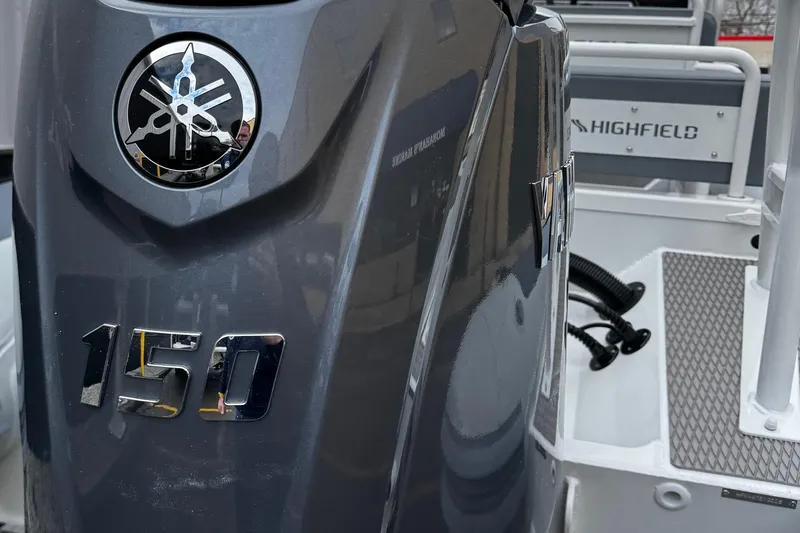 Slide: The Image of 2026 Highfield Patrol 600 boat with seating and control console, docked near a building. - 7