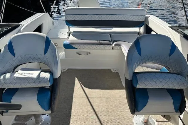 Slide: The Image of 2019 Hurricane SunDeck 2410 OB interior with blue and white seating, on calm water. - 11