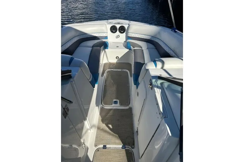 Slide: The Image of 2019 Hurricane SunDeck 2410 OB boat interior with seating and dashboard, on calm water. - 20