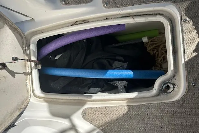 Slide: The Image of Storage compartment on 2019 Hurricane SunDeck 2410 OB with pool noodles and rope. - 24