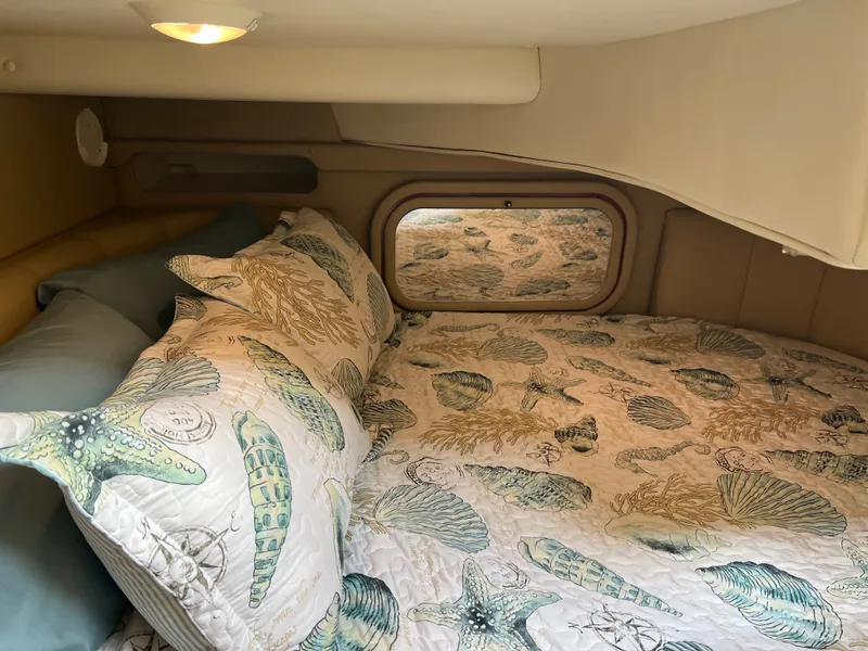 Slide: The Image of Cozy cabin interior of 2003 Rinker Fiesta Vee 342 with seashell-themed bedding. - 10