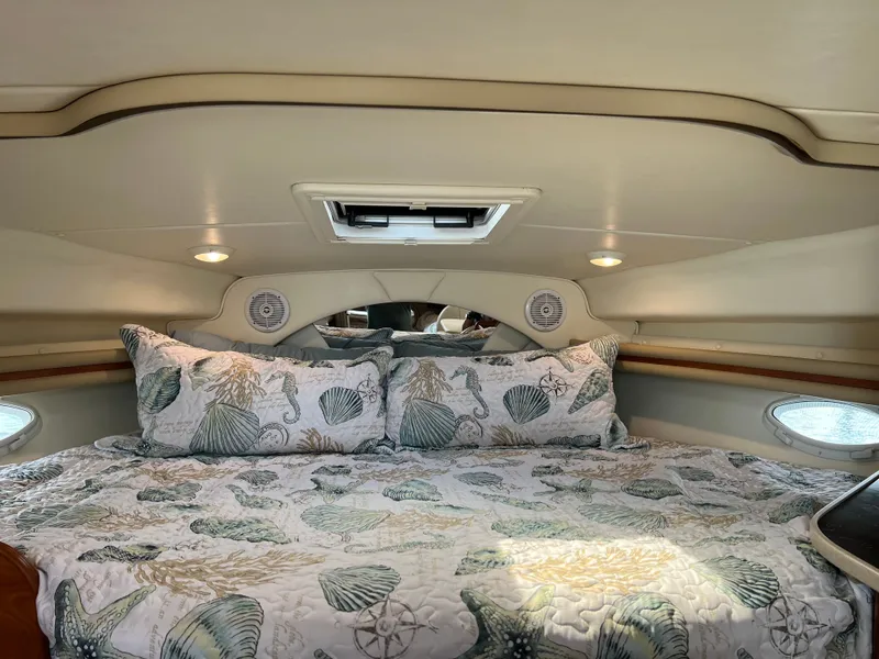 Slide: The Image of Cozy cabin interior of 2003 Rinker Fiesta Vee 342 with nautical-themed bedding. - 13
