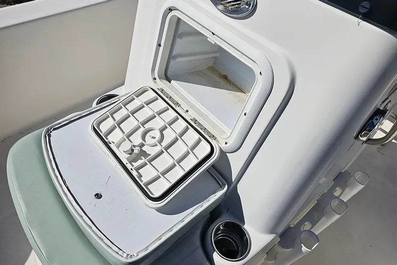 Slide: The Image of 2016 Sundance DX20 boat storage compartment with open hatch and cup holders. - 17
