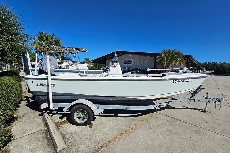 Slide: The Image of 2016 Sundance DX20 boat on trailer in sunny outdoor setting. - 6