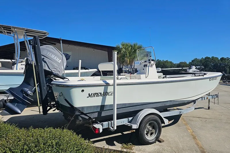 Slide: The Image of 2016 Sundance DX20 boat on trailer with Yamaha outboard motor, parked outdoors. - 7