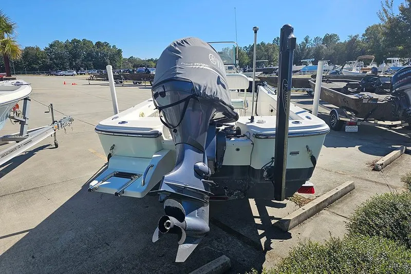 Slide: The Image of 2016 Sundance DX20 boat with covered outboard motor in a marina parking lot. - 8