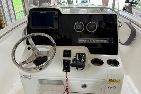 Slide: The Image of 2017 Tidewater 210 LXF boat dashboard with steering wheel and navigation controls. - 15