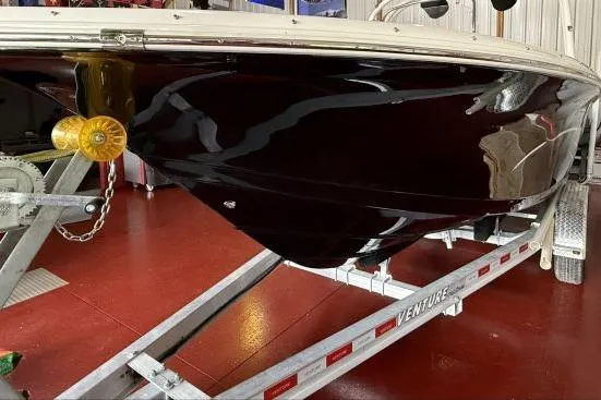 Slide: The Image of 2017 Tidewater 210 LXF boat on trailer, glossy black hull, indoor setting. - 5