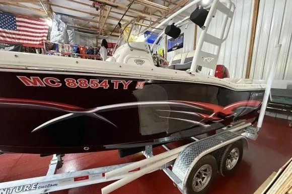 Slide: The Image of 2017 Tidewater 210 LXF boat on trailer in garage with custom graphics. - 7