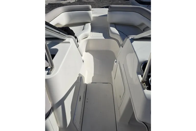 Slide: The Image of 2013 Bayliner 190 Deck Boat interior with white seating and storage compartments. - 10