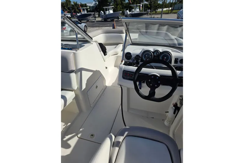 Slide: The Image of 2013 Bayliner 190 Deck Boat cockpit with steering wheel and dashboard controls. - 8