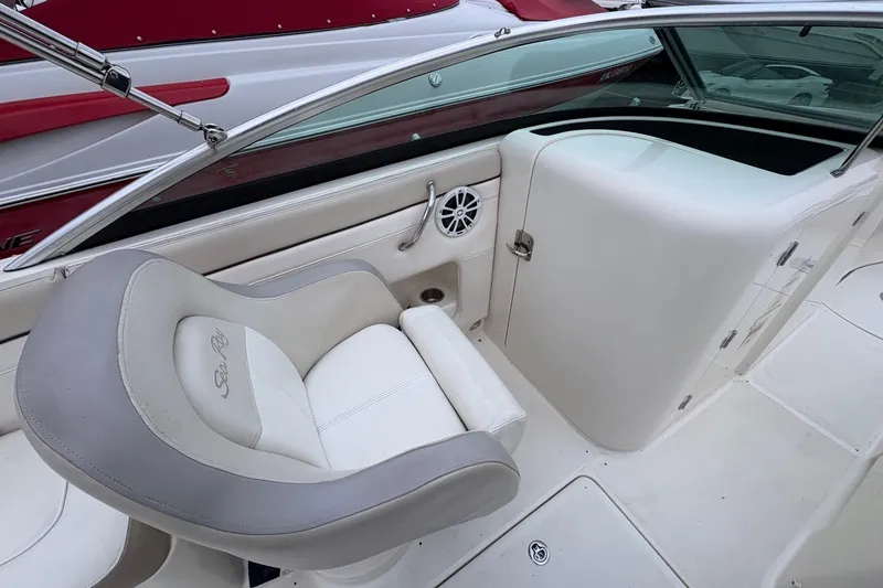 Slide: The Image of 2013 Sea Ray 280 Sundeck interior with white and gray seating, speaker, and storage compartment. - 14