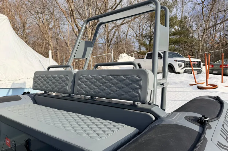 Slide: The Image of 2026 Highfield Patrol 660 boat with quilted seating, parked in snowy outdoor setting. - 16