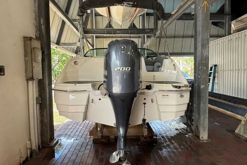 Slide: The Image of 2023 NauticStar 243 DC boat with Yamaha 200 engine in storage facility. - 11
