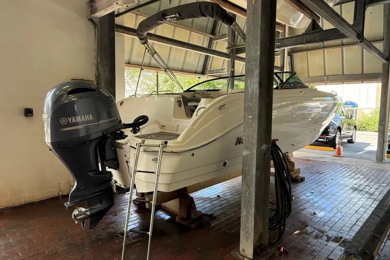 Slide: The Image of 2023 NauticStar 243 DC boat with Yamaha engine in a covered dock. - 13