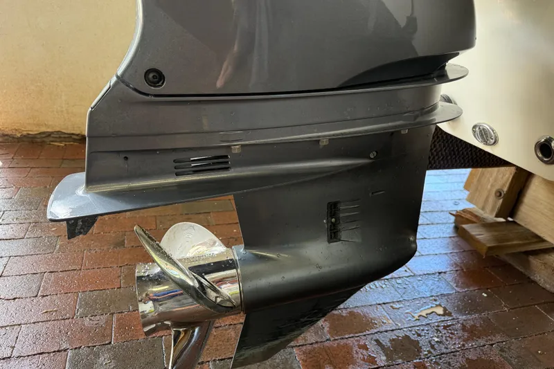 Slide: The Image of 2023 NauticStar 243 DC boat motor and propeller on wet brick surface. - 18