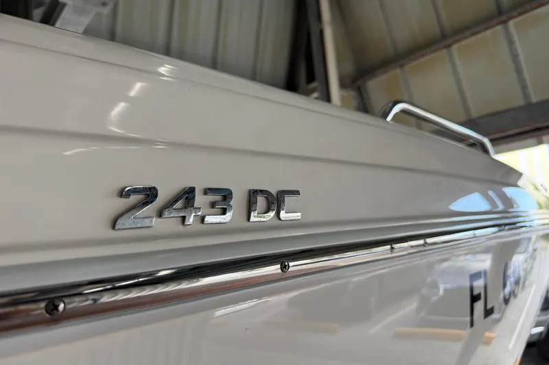 Slide: The Image of 2023 NauticStar 243 DC boat side view in a garage setting. - 20