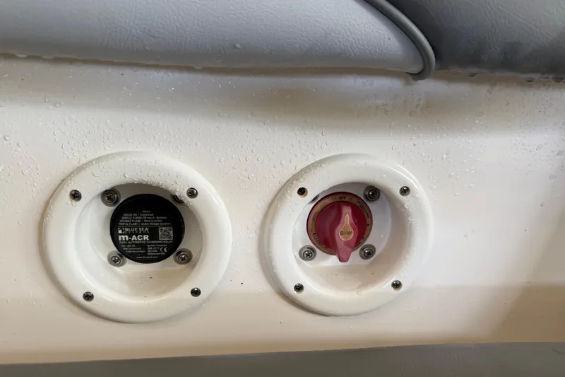 Slide: The Image of Boat control panel with switches on a 2023 NauticStar 243 DC, featuring water droplets. - 26