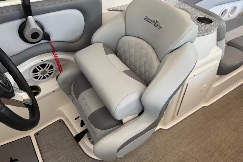 Slide: The Image of 2023 NauticStar 243 DC boat interior with plush captain's chair and modern controls. - 38