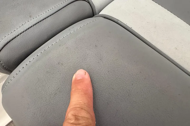 Slide: The Image of Close-up of 2023 NauticStar 243 DC boat seat with visible wear and stitching. - 49