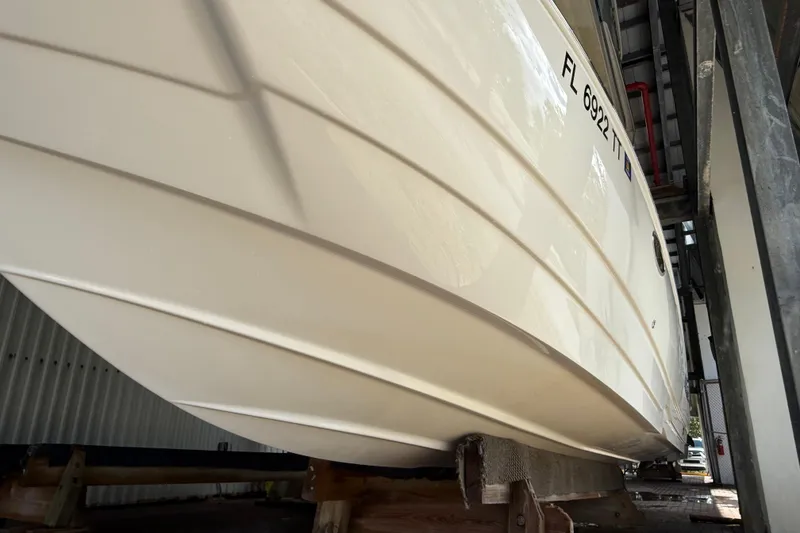 Slide: The Image of 2023 NauticStar 243 DC boat hull in storage, side view. - 5