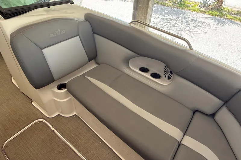 Slide: The Image of 2023 NauticStar 243 DC boat interior with gray seating and cup holders. - 51