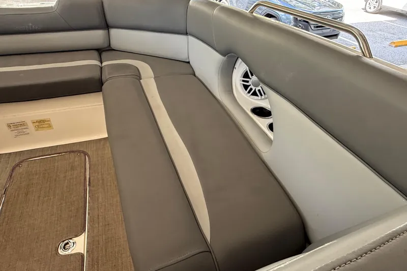 Slide: The Image of 2023 NauticStar 243 DC boat interior with gray seating and speaker detail. - 56