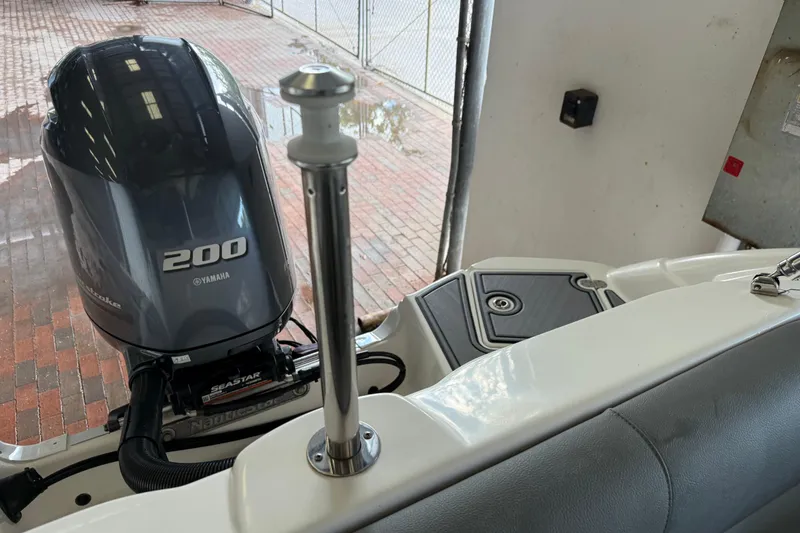 Slide: The Image of 2023 NauticStar 243 DC boat with Yamaha 200 engine, docked indoors. - 8