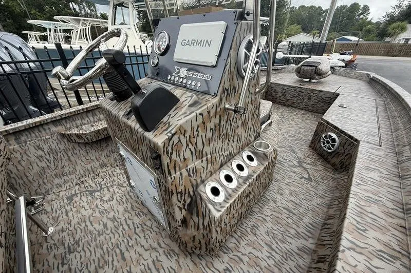 Slide: The Image of 2026 Xpress H22B Bay boat interior with camouflage design and Garmin navigation system. - 10
