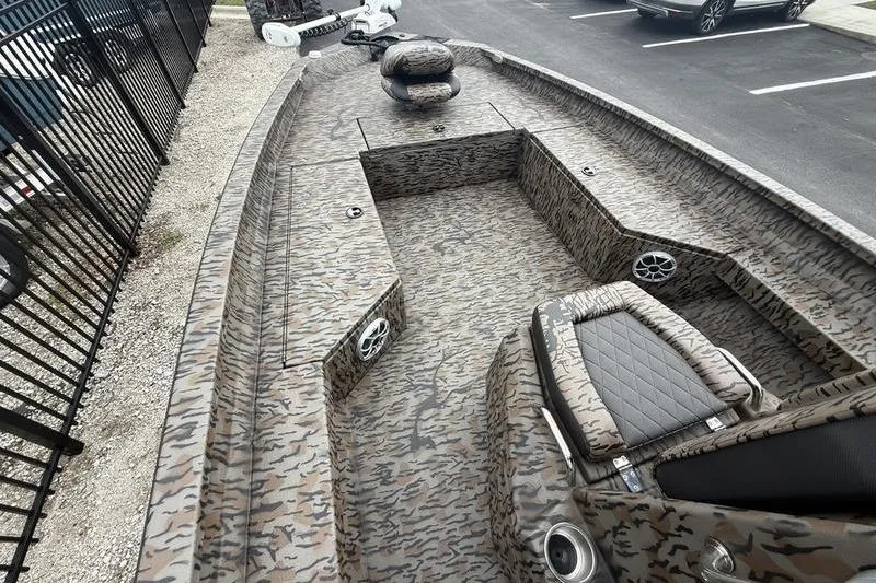 Slide: The Image of 2026 Xpress H22B Bay boat with camo interior and seating, parked outdoors. - 6