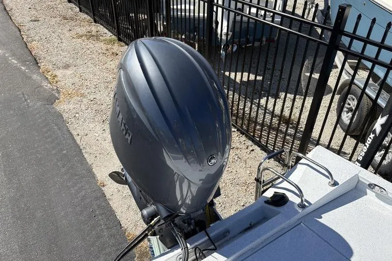 Slide: The Image of 2026 Xpress H20B Bay boat with Yamaha outboard motor, parked near a fence. - 14
