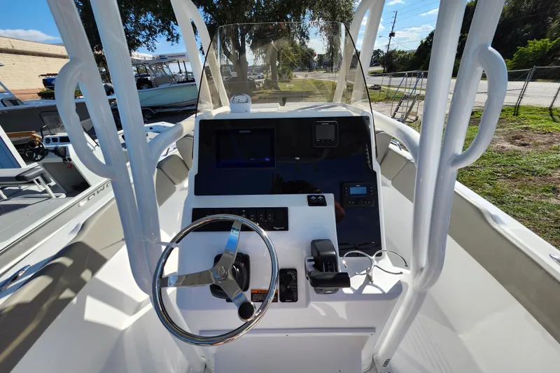 Slide: The Image of 2025 Savannah 2200 Offshore boat dashboard with steering wheel and navigation controls. - 16