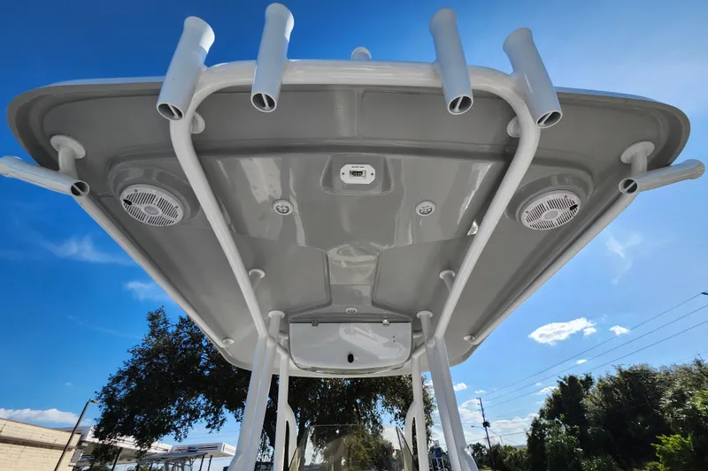 Slide: The Image of 2025 Savannah 2200 Offshore boat canopy with rod holders and speakers under clear blue sky. - 27