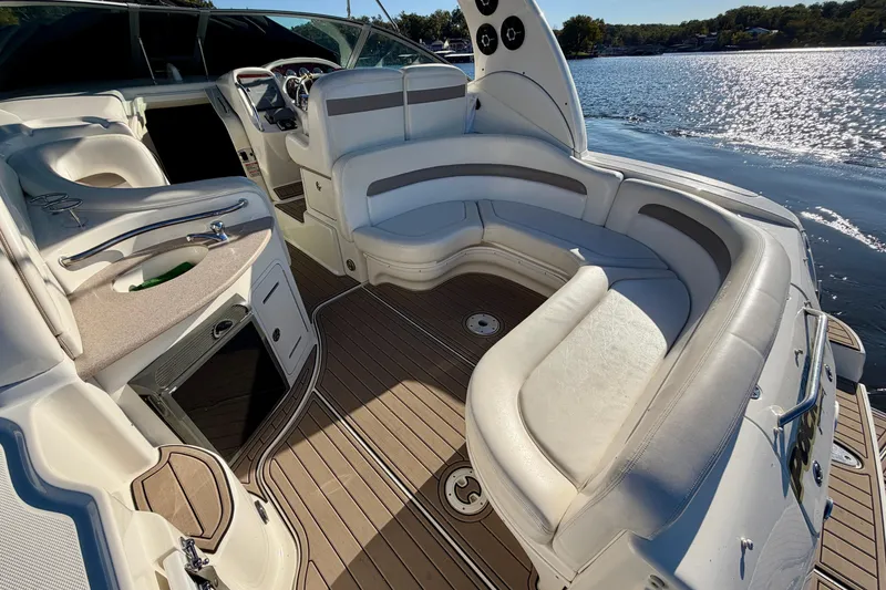 Slide: The Image of 2004 Sea Ray 320 Sundancer boat interior with plush seating and elegant design on the water. - 10