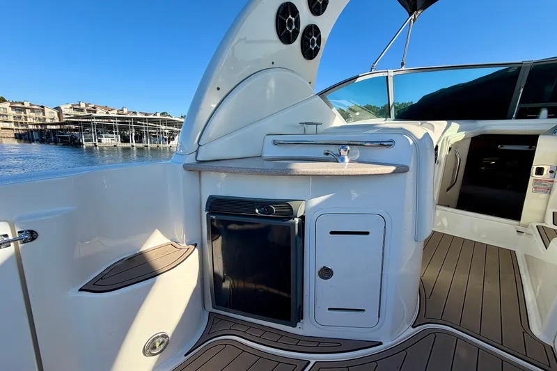 Slide: The Image of 2004 Sea Ray 320 Sundancer boat interior with kitchenette and scenic marina view. - 12