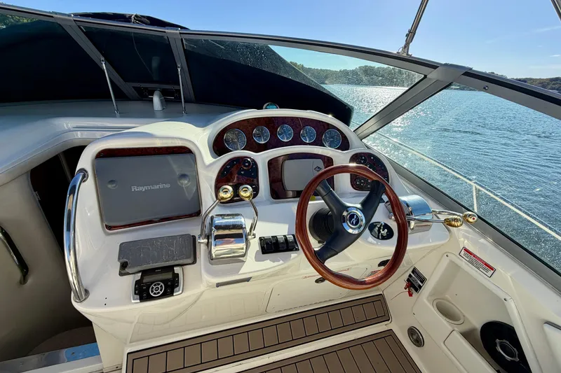 Slide: The Image of Cockpit of 2004 Sea Ray 320 Sundancer with steering wheel and control panel, overlooking water. - 15