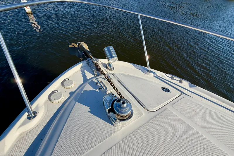 Slide: The Image of Bow of 2004 Sea Ray 320 Sundancer with anchor and railing on calm water. - 23