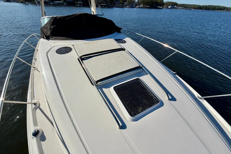 Slide: The Image of 2004 Sea Ray 320 Sundancer boat deck on calm water, sunny day. - 24