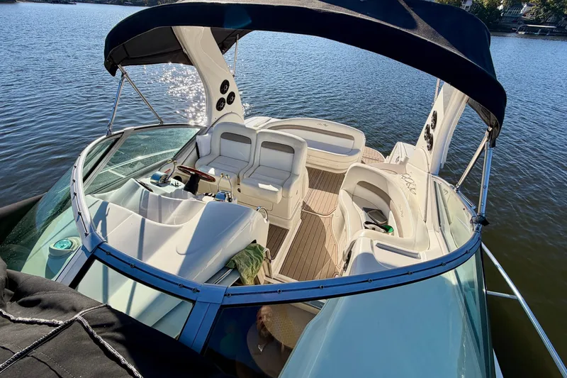 Slide: The Image of 2004 Sea Ray 320 Sundancer boat with spacious deck and seating on calm water. - 25