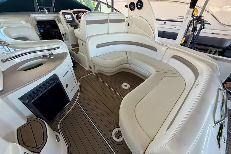 Slide: The Image of 2004 Sea Ray 320 Sundancer interior with curved seating and wood-style flooring. - 28
