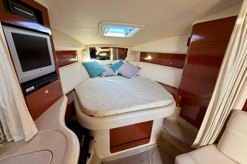 Slide: The Image of Luxurious cabin interior of 2004 Sea Ray 320 Sundancer with cozy bed and TV. - 30