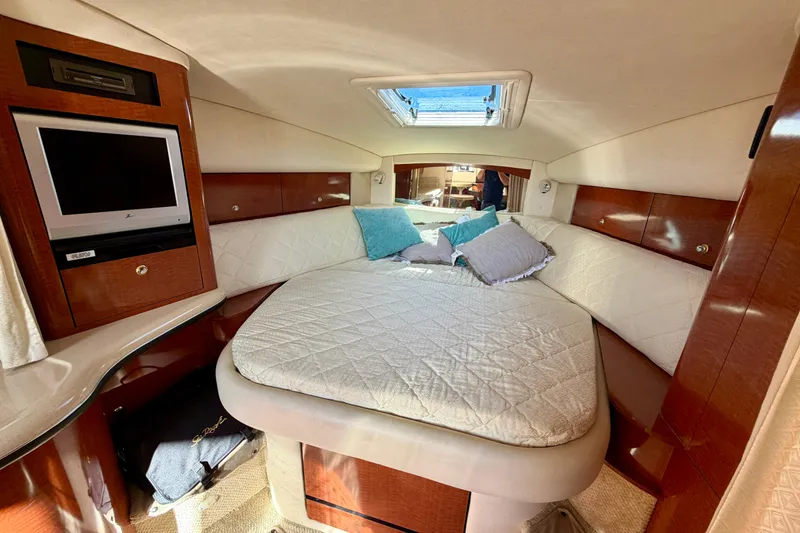 Slide: The Image of Luxurious cabin interior of 2004 Sea Ray 320 Sundancer with bed and TV. - 31